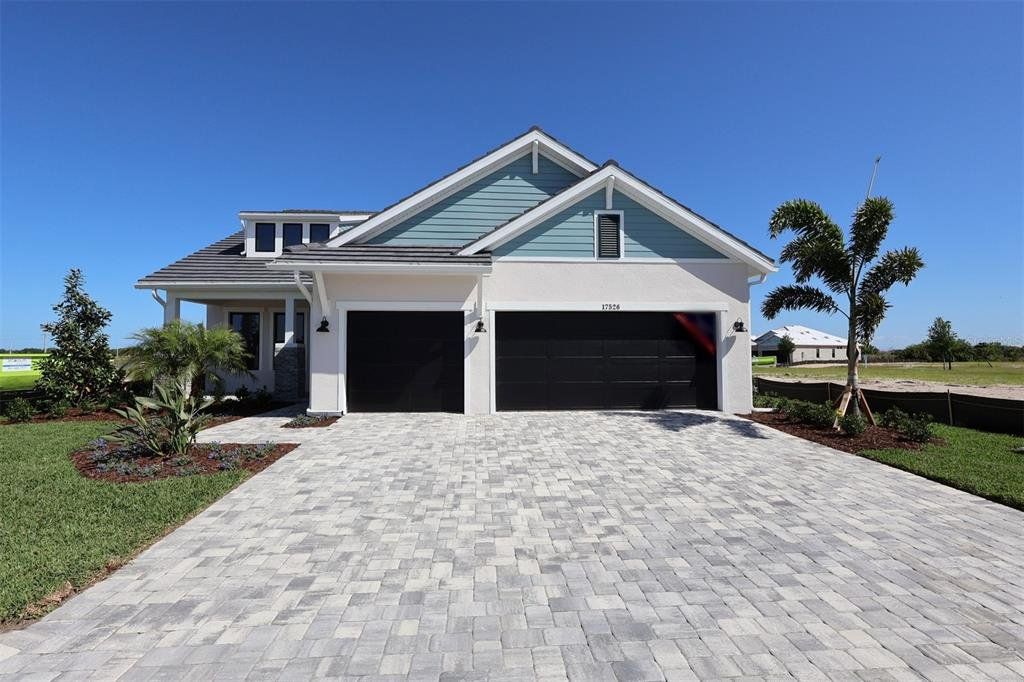 Front exterior of a new home in Palmera Wellen Park - Classic Series, Venice, FL, highlighting curb appeal (Image 1). Front exterior of a new home in Palmera Wellen Park - Classic Series, Venice, FL, highlighting curb appeal (Image 1).