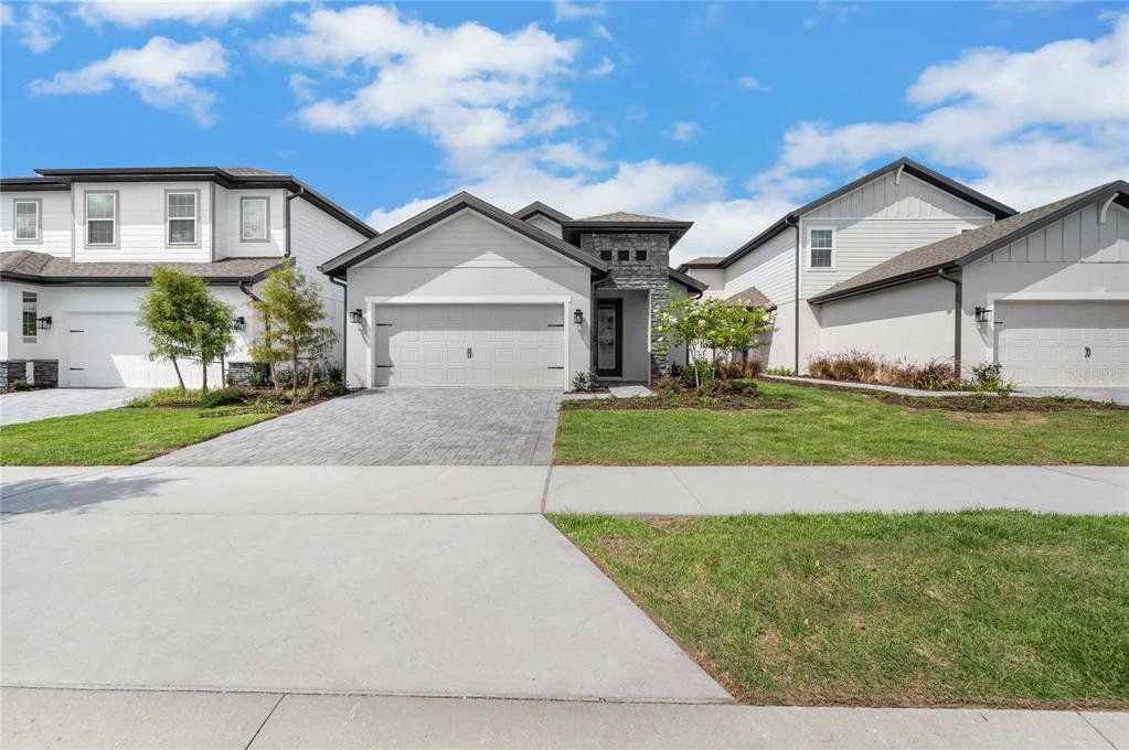 Front exterior of a new home in Reunion Village, Kissimmee, FL, highlighting curb appeal (Image 1). Front exterior of a new home in Reunion Village, Kissimmee, FL, highlighting curb appeal (Image 1).