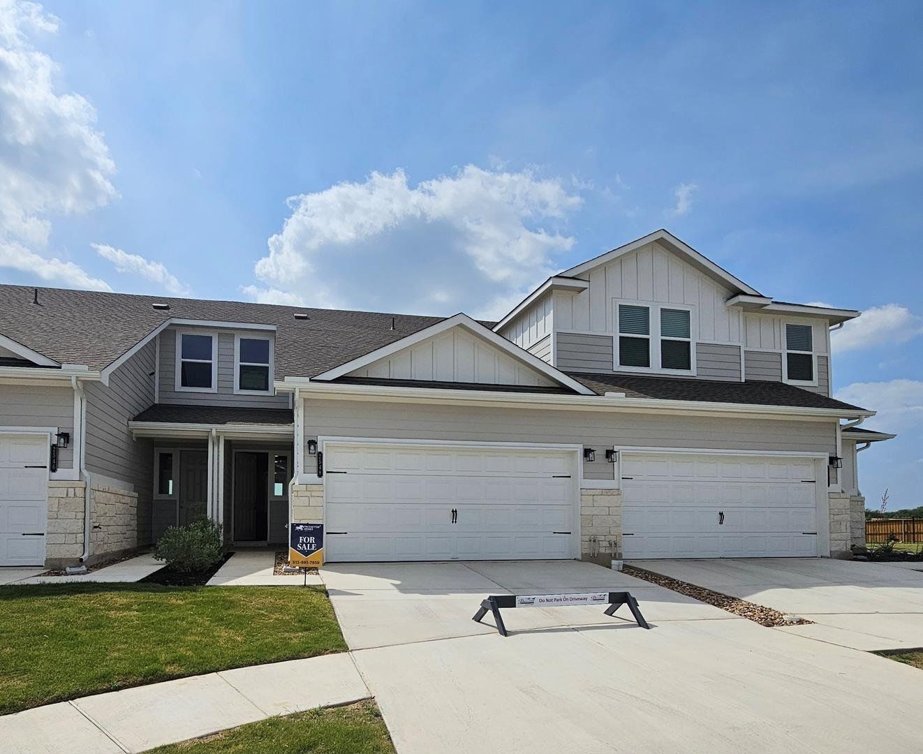 Craftsman inspired home with stone siding, board and batten siding, concrete driveway, roof with shingles, and a front lawn Craftsman inspired home with stone siding, board and batten siding, concrete driveway, roof with shingles, and a front lawn