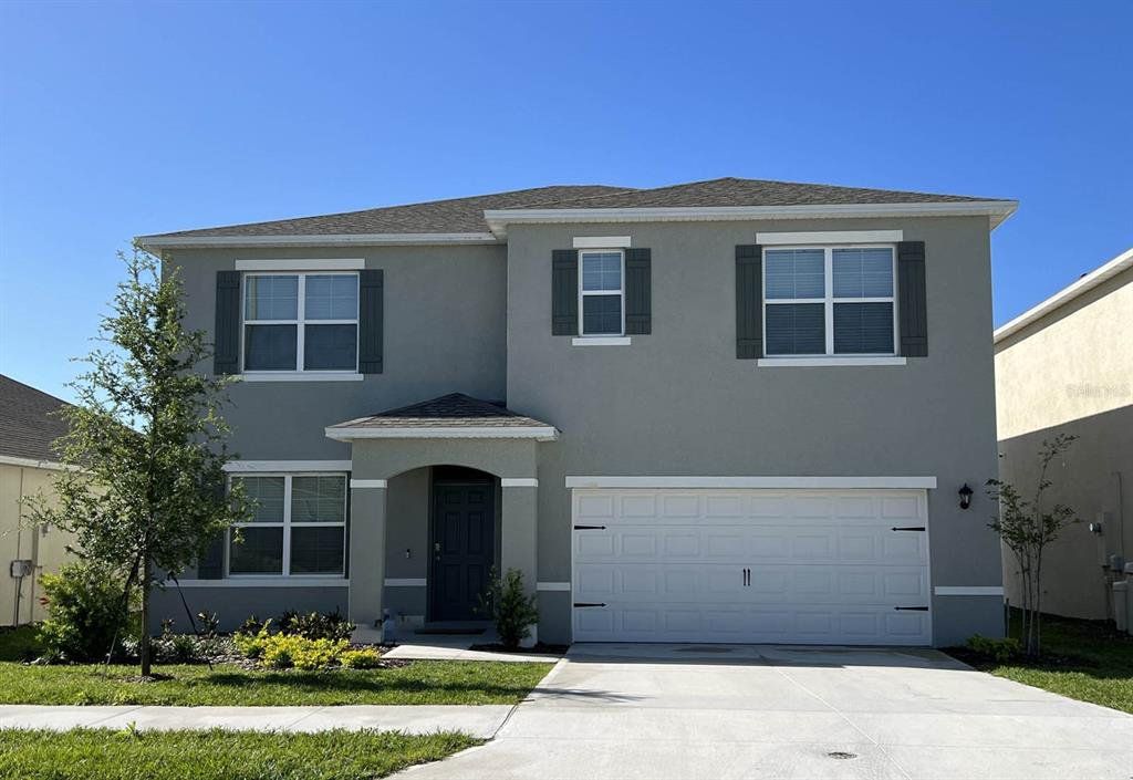 Front exterior of a new home in Cascades, Davenport, FL, highlighting curb appeal (Image 1). Front exterior of a new home in Cascades, Davenport, FL, highlighting curb appeal (Image 1).