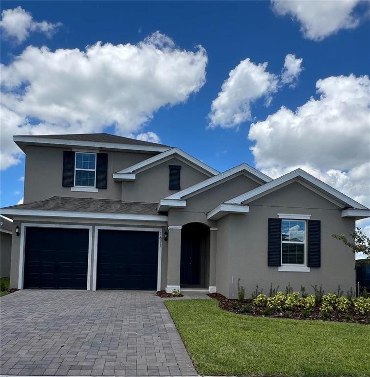 Front exterior of a new home in Hills of Minneola, Minneola, FL, highlighting curb appeal (Image 1).