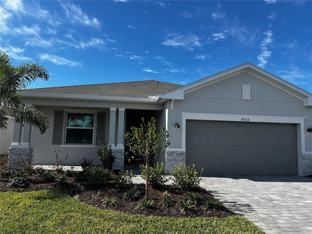 Front exterior of a new home in Island Lakes at Coco Bay: Executive Homes, Englewood, FL, highlighting curb appeal (Image 1).