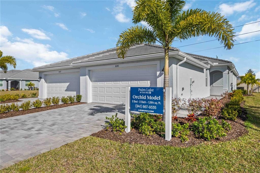 Front exterior of a new home in Palm Lake at Coco Bay, Englewood, FL, highlighting curb appeal (Image 1). Front exterior of a new home in Palm Lake at Coco Bay, Englewood, FL, highlighting curb appeal (Image 1).