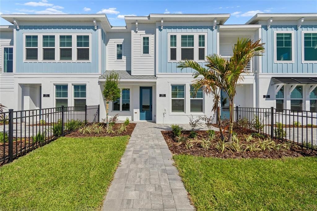 Front exterior of a new home in Emerald Landing at Waterside at Lakewood Ranch – Towns, Sarasota, FL, highlighting curb appeal (Image 1). Front exterior of a new home in Emerald Landing at Waterside at Lakewood Ranch – Towns, Sarasota, FL, highlighting curb appeal (Image 1).