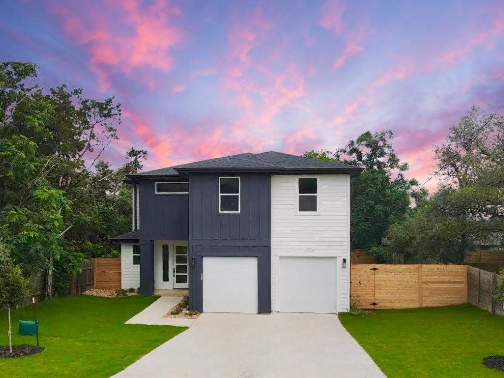 A modern facade with striking dark and light siding offers curb appeal and a spacious driveway. A modern facade with striking dark and light siding offers curb appeal and a spacious driveway.