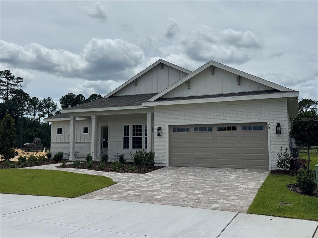 Front exterior of a new home in Laureate Village, Newberry, FL, highlighting curb appeal (Image 1). Front exterior of a new home in Laureate Village, Newberry, FL, highlighting curb appeal (Image 1).
