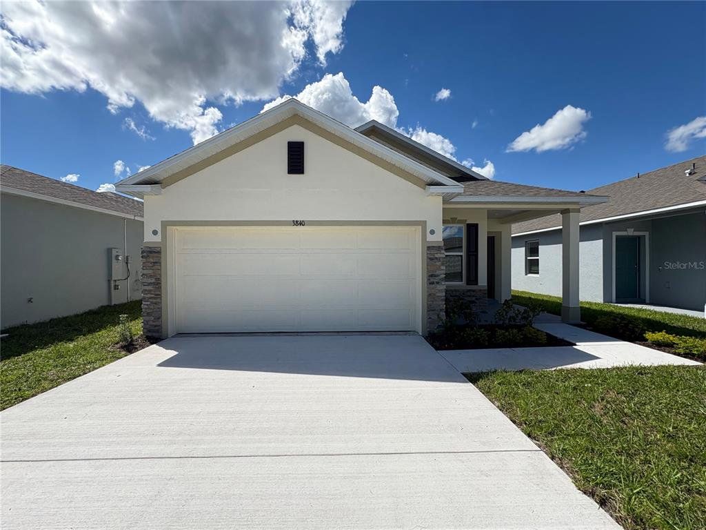 Front exterior of a new home in Lake Deer Estates, Poinciana, FL, highlighting curb appeal (Image 1). Front exterior of a new home in Lake Deer Estates, Poinciana, FL, highlighting curb appeal (Image 1).