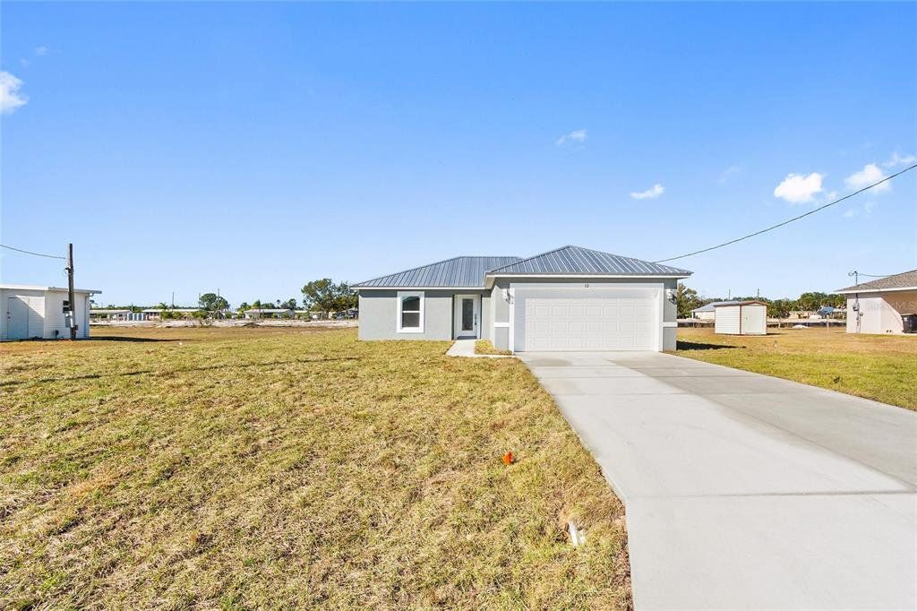 Front exterior of a new home in , Frostproof, FL, highlighting curb appeal (Image 1). Front exterior of a new home in , Frostproof, FL, highlighting curb appeal (Image 1).