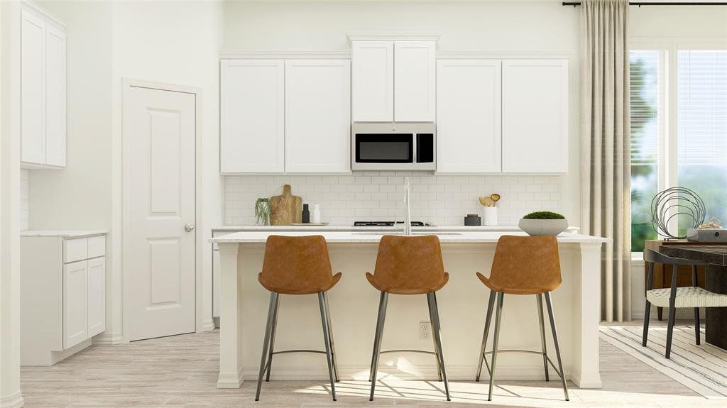 The kitchen features white cabinetry, a white subway tile backsplash, and a stainless steel microwave The kitchen features white cabinetry, a white subway tile backsplash, and a stainless steel microwave