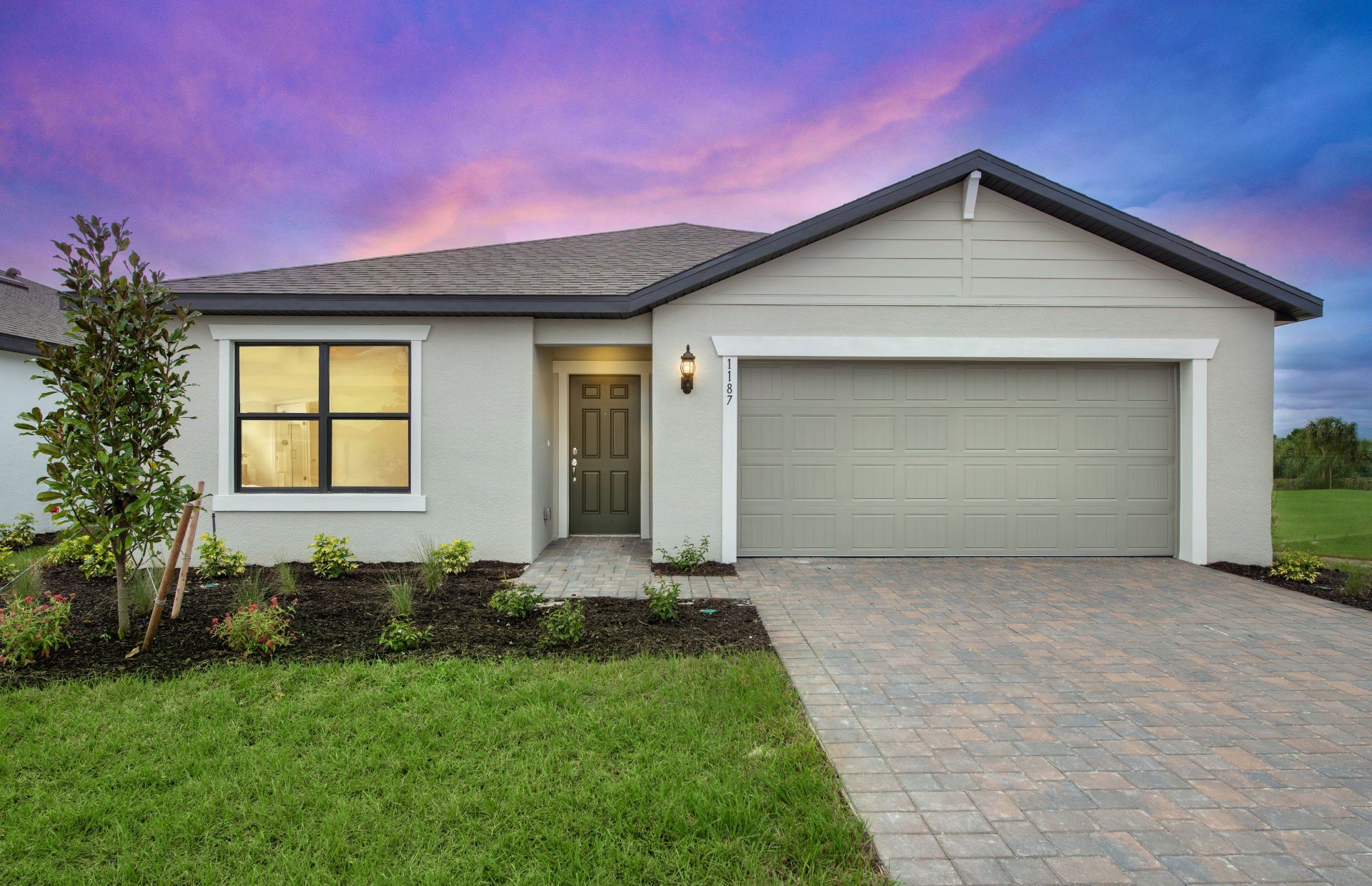 Front exterior of a new home in Whispering Lakes, Lehigh Acres, FL, highlighting curb appeal (Image 1). Front exterior of a new home in Whispering Lakes, Lehigh Acres, FL, highlighting curb appeal (Image 1).