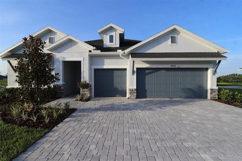 Front exterior of a new home in Chapel Crossings, Wesley Chapel, FL, highlighting curb appeal (Image 1).