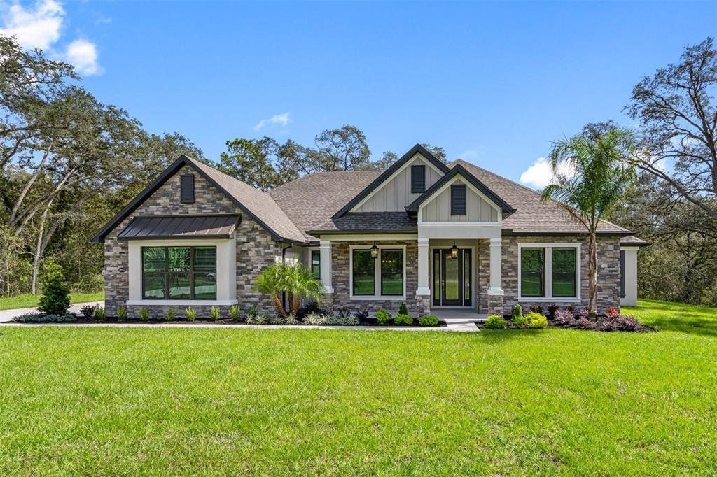 Front exterior of a new home in Bella Terra, Hudson, FL, highlighting curb appeal (Image 1). Front exterior of a new home in Bella Terra, Hudson, FL, highlighting curb appeal (Image 1).