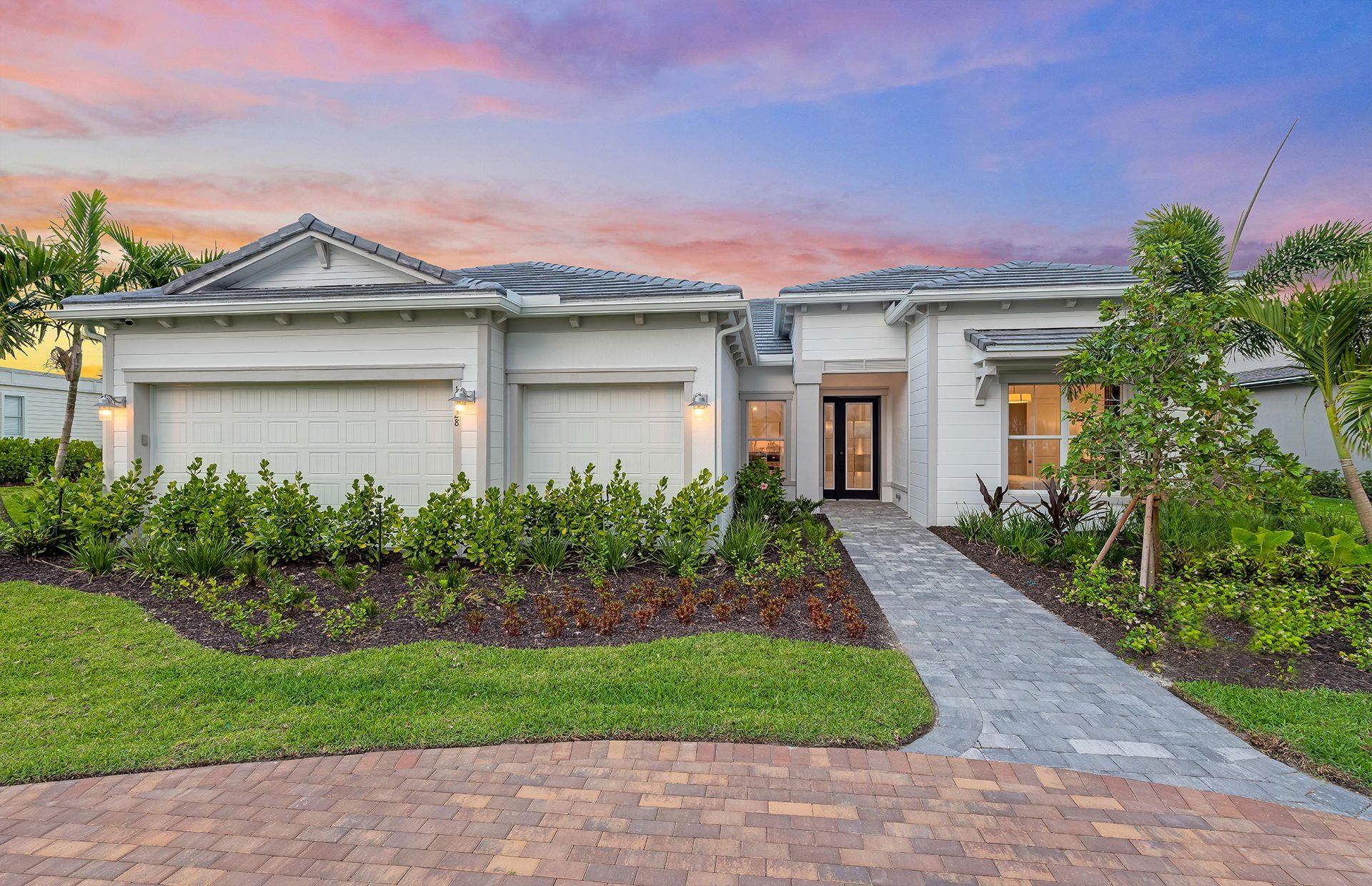 Front exterior of a new home in Avondale at Avenir, Palm Beach Gardens, FL, highlighting curb appeal (Image 1).