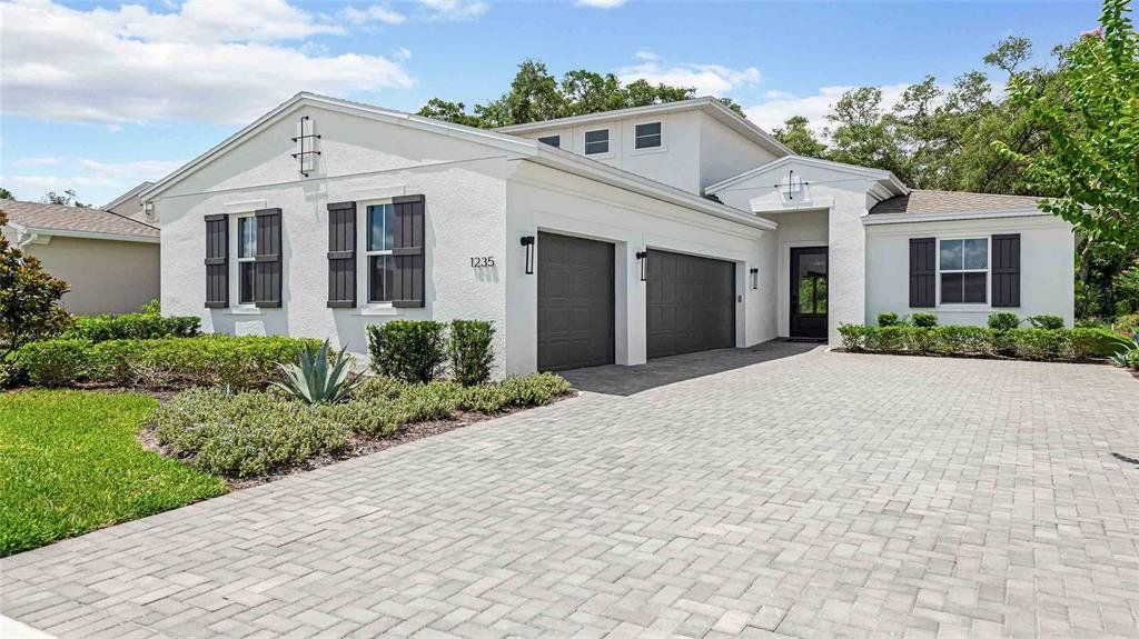 Front exterior of a new home in Cresswind DeLand, Deland, FL, highlighting curb appeal (Image 1). Front exterior of a new home in Cresswind DeLand, Deland, FL, highlighting curb appeal (Image 1).