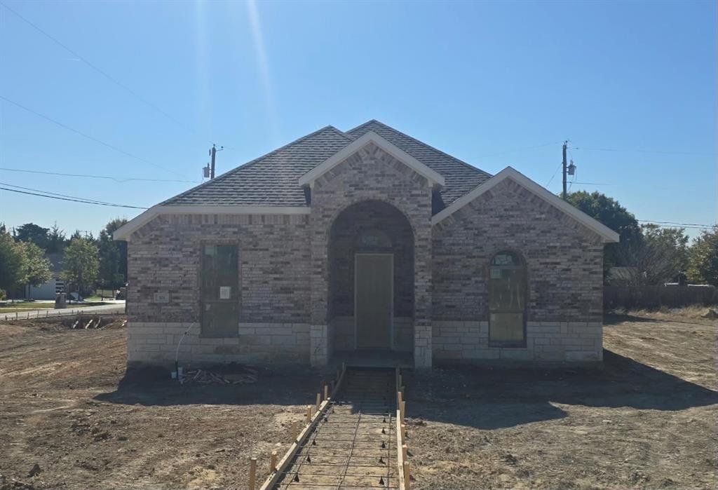 French country style house with brick siding and roof with shingles