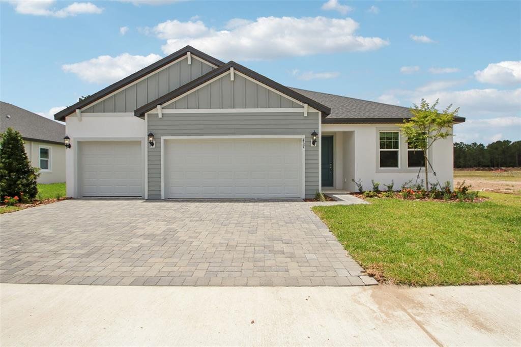 Front exterior of a new home in Ridgehaven - Reserve Series, Ormond Beach, FL, highlighting curb appeal (Image 1). Front exterior of a new home in Ridgehaven - Reserve Series, Ormond Beach, FL, highlighting curb appeal (Image 1).