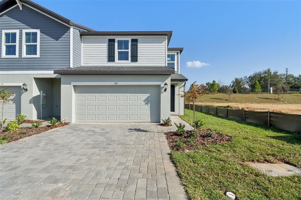 Front exterior of a new home in The Reserve at Hammock Oaks Townes, Lady Lake, FL, highlighting curb appeal (Image 1). Front exterior of a new home in The Reserve at Hammock Oaks Townes, Lady Lake, FL, highlighting curb appeal (Image 1).