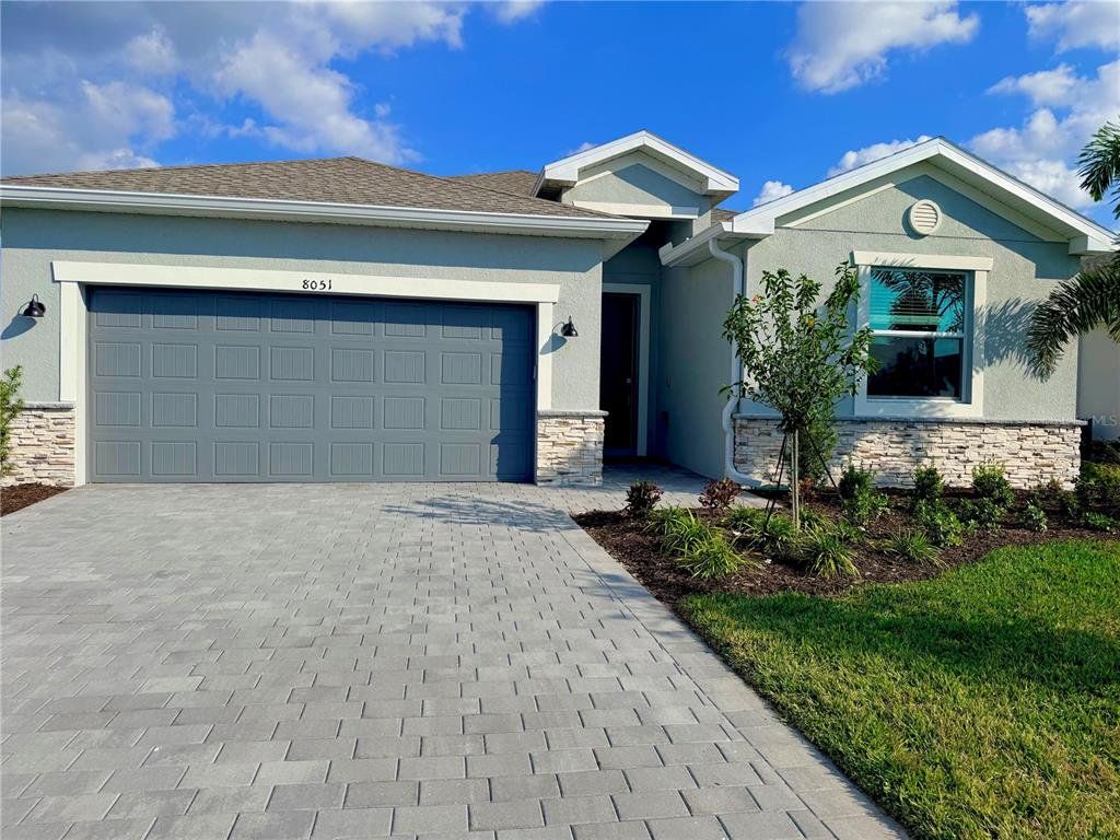 Front exterior of a new home in Island Lakes at Coco Bay, Englewood, FL, highlighting curb appeal (Image 1). Front exterior of a new home in Island Lakes at Coco Bay, Englewood, FL, highlighting curb appeal (Image 1).