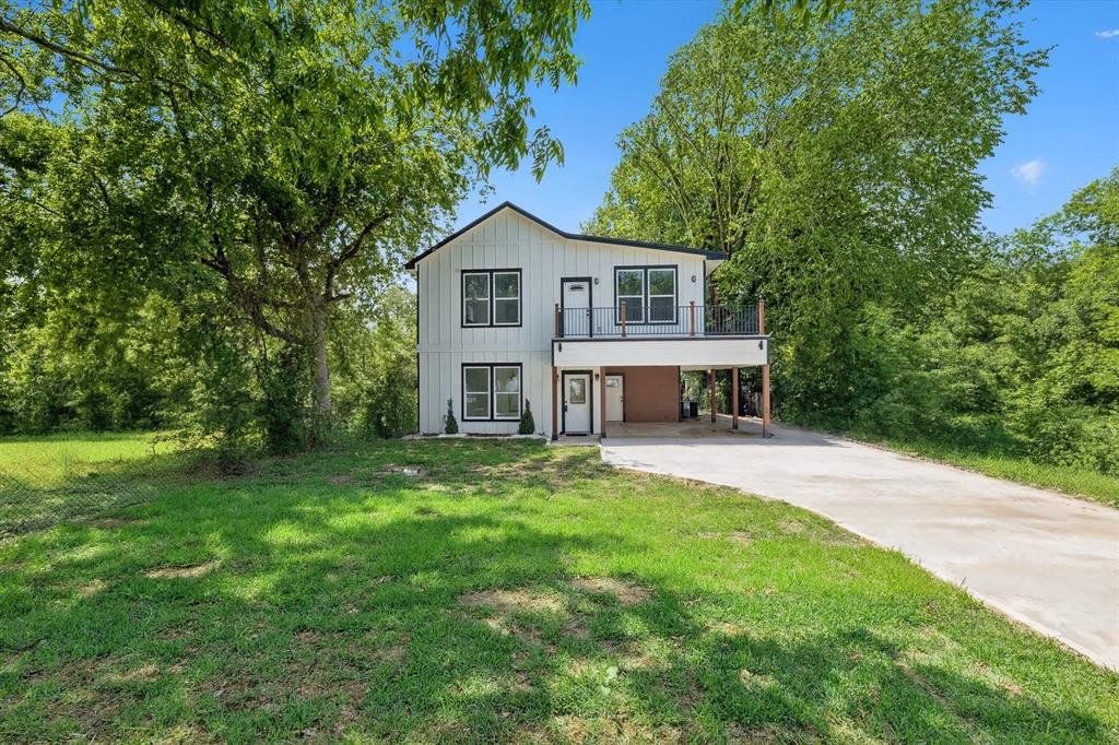 View of front of house featuring driveway and a front yard