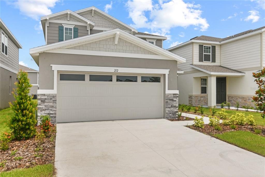 Front exterior of a new home in Seasons at Magnolia Pointe, Umatilla, FL, highlighting curb appeal (Image 1).