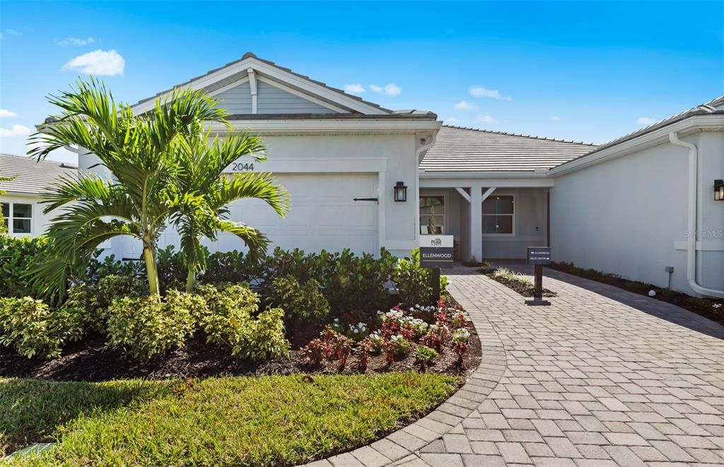 Front exterior of a new home in Shores at Stillwater, Englewood, FL, highlighting curb appeal (Image 1). Front exterior of a new home in Shores at Stillwater, Englewood, FL, highlighting curb appeal (Image 1).