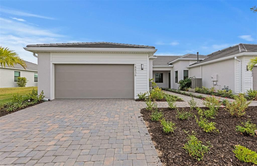 Front exterior of a new home in Del Webb Catalina, Lakewood Ranch, FL, highlighting curb appeal (Image 1). Front exterior of a new home in Del Webb Catalina, Lakewood Ranch, FL, highlighting curb appeal (Image 1).