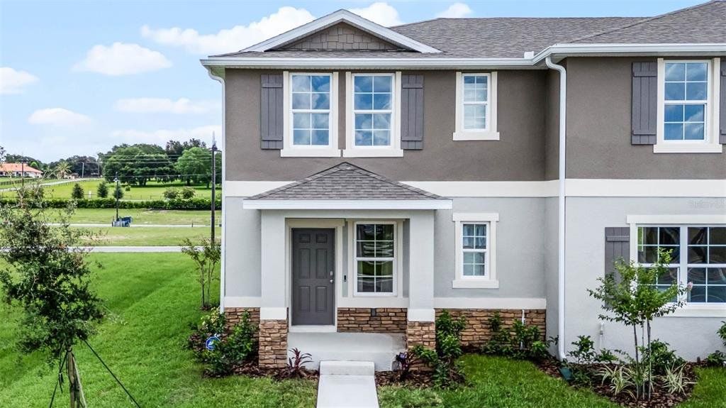 Front exterior of a new home in Windrose, Apopka, FL, highlighting curb appeal (Image 1). Front exterior of a new home in Windrose, Apopka, FL, highlighting curb appeal (Image 1).