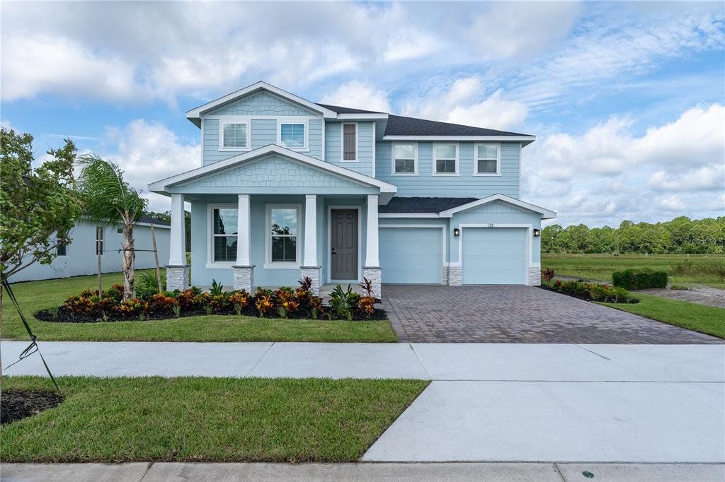 Front exterior of a new home in The Palms at Venetian Bay, New Smyrna Beach, FL, highlighting curb appeal (Image 1). Front exterior of a new home in The Palms at Venetian Bay, New Smyrna Beach, FL, highlighting curb appeal (Image 1).