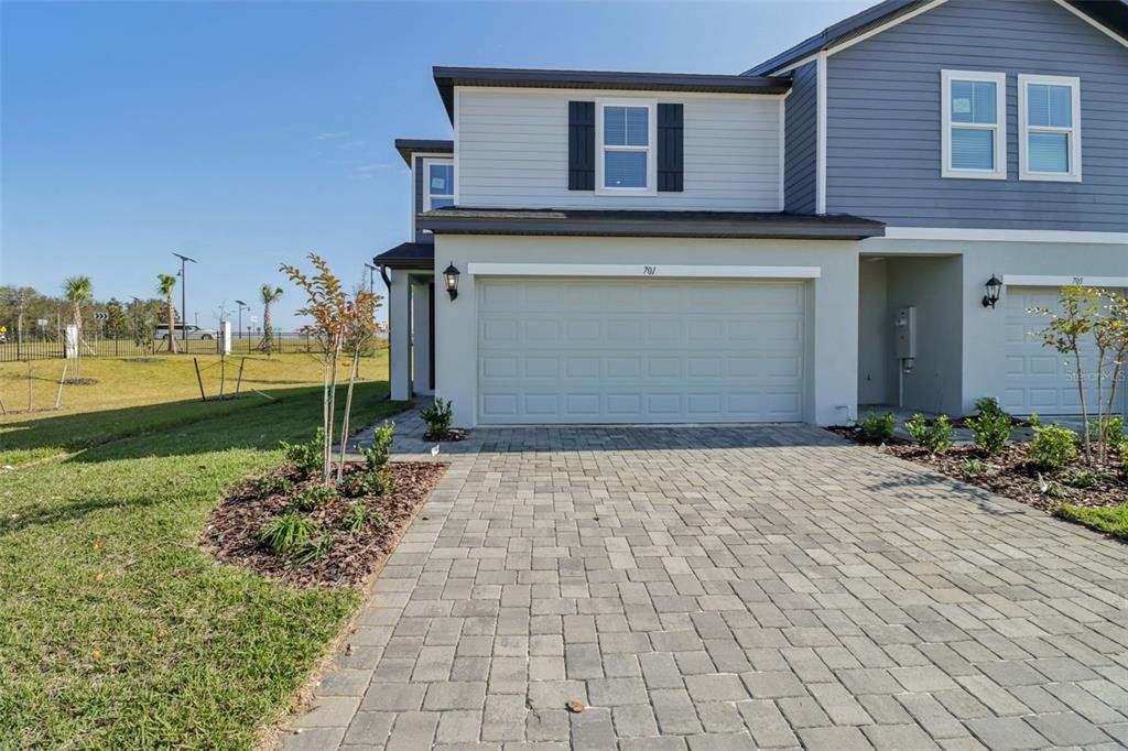 Front exterior of a new home in The Reserve at Hammock Oaks Townes, Lady Lake, FL, highlighting curb appeal (Image 1). Front exterior of a new home in The Reserve at Hammock Oaks Townes, Lady Lake, FL, highlighting curb appeal (Image 1).