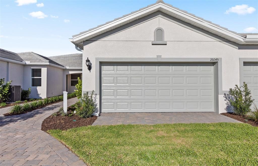 Front exterior of a new home in BeachWalk by Manasota Key, Englewood, FL, highlighting curb appeal (Image 1). Front exterior of a new home in BeachWalk by Manasota Key, Englewood, FL, highlighting curb appeal (Image 1).