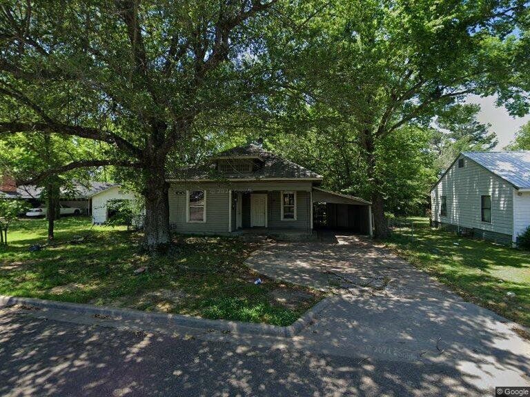 Bungalow-style house featuring asphalt driveway, a carport, a front lawn, and a patio