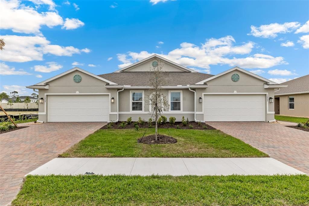Front exterior of a new home in Cove at West Port - Express, Port Charlotte, FL, highlighting curb appeal (Image 1). Front exterior of a new home in Cove at West Port - Express, Port Charlotte, FL, highlighting curb appeal (Image 1).