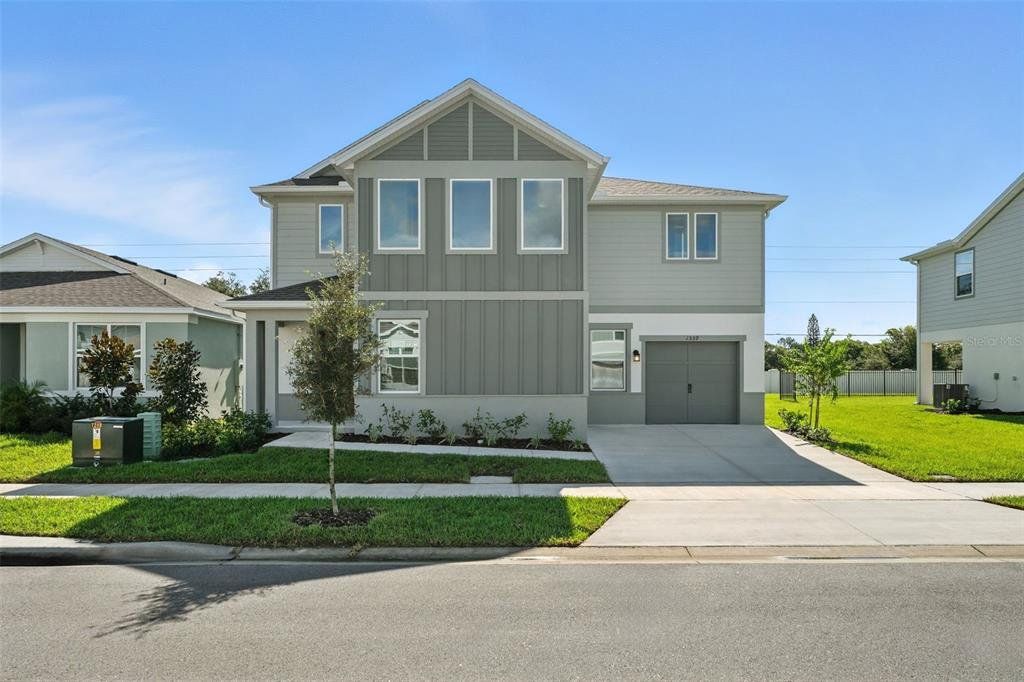 Front exterior of a new home in Amelia Groves, St. Cloud, FL, highlighting curb appeal (Image 1). Front exterior of a new home in Amelia Groves, St. Cloud, FL, highlighting curb appeal (Image 1).
