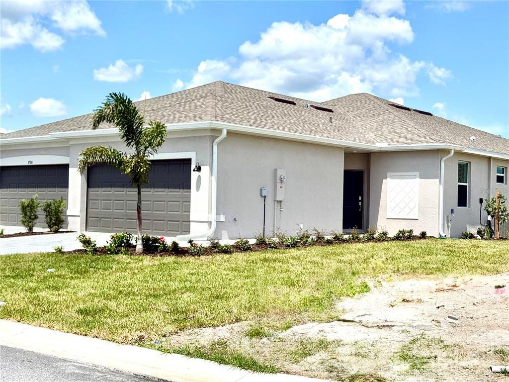 Front exterior of a new home in Island Lakes at Coco Bay, Englewood, FL, highlighting curb appeal (Image 1). Front exterior of a new home in Island Lakes at Coco Bay, Englewood, FL, highlighting curb appeal (Image 1).