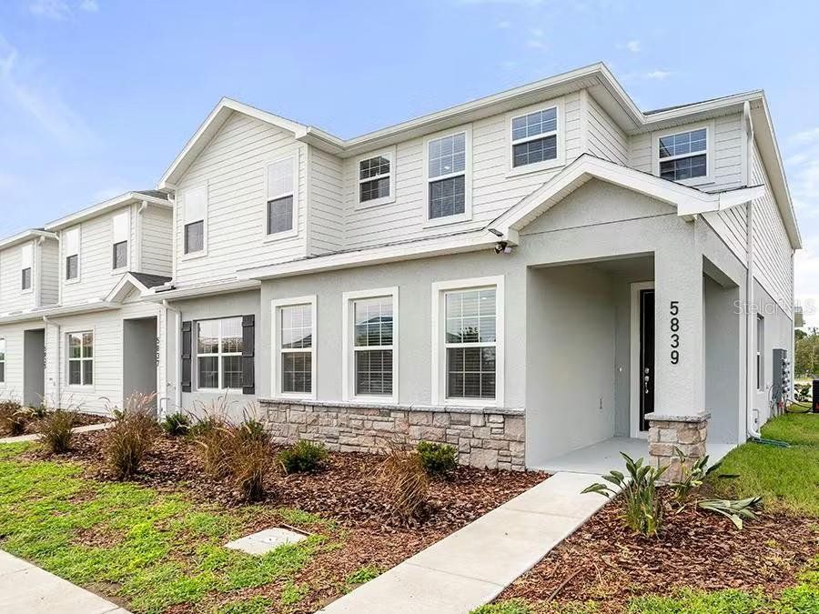 Front exterior of a new home in The Crossings - Townhomes, St. Cloud, FL, highlighting curb appeal (Image 1). Front exterior of a new home in The Crossings - Townhomes, St. Cloud, FL, highlighting curb appeal (Image 1).