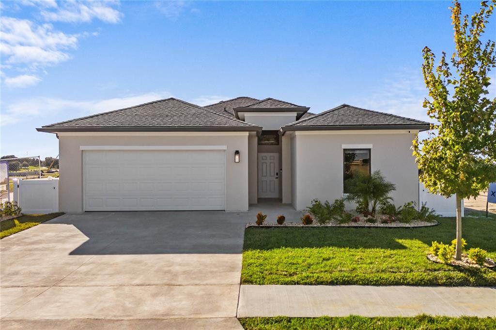 Front exterior of a new home in , Mascotte, FL, highlighting curb appeal (Image 1).