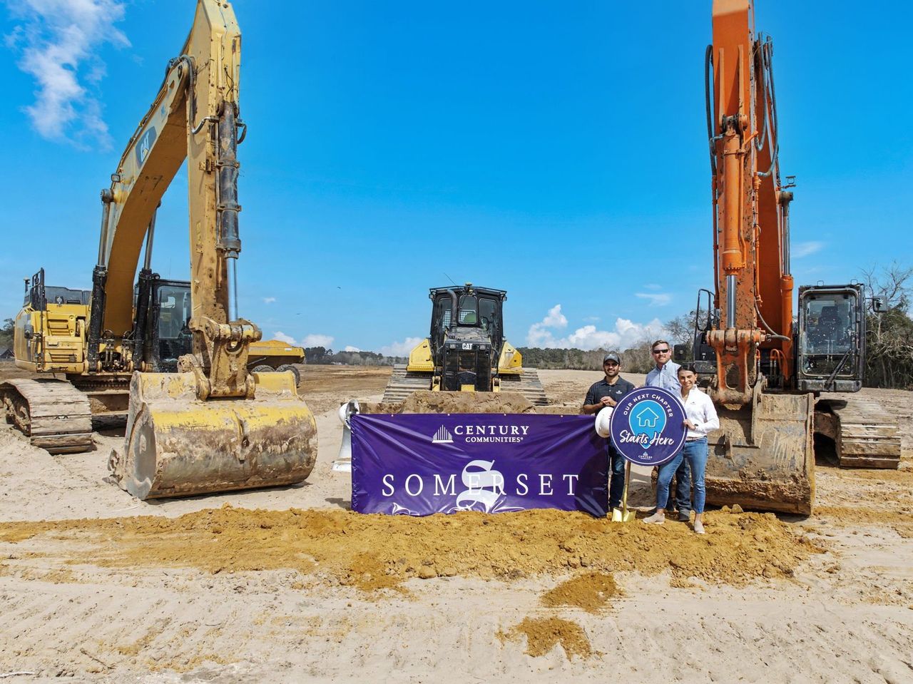 A few men standing next to a sign and a construction site. A few men standing next to a sign and a construction site.
