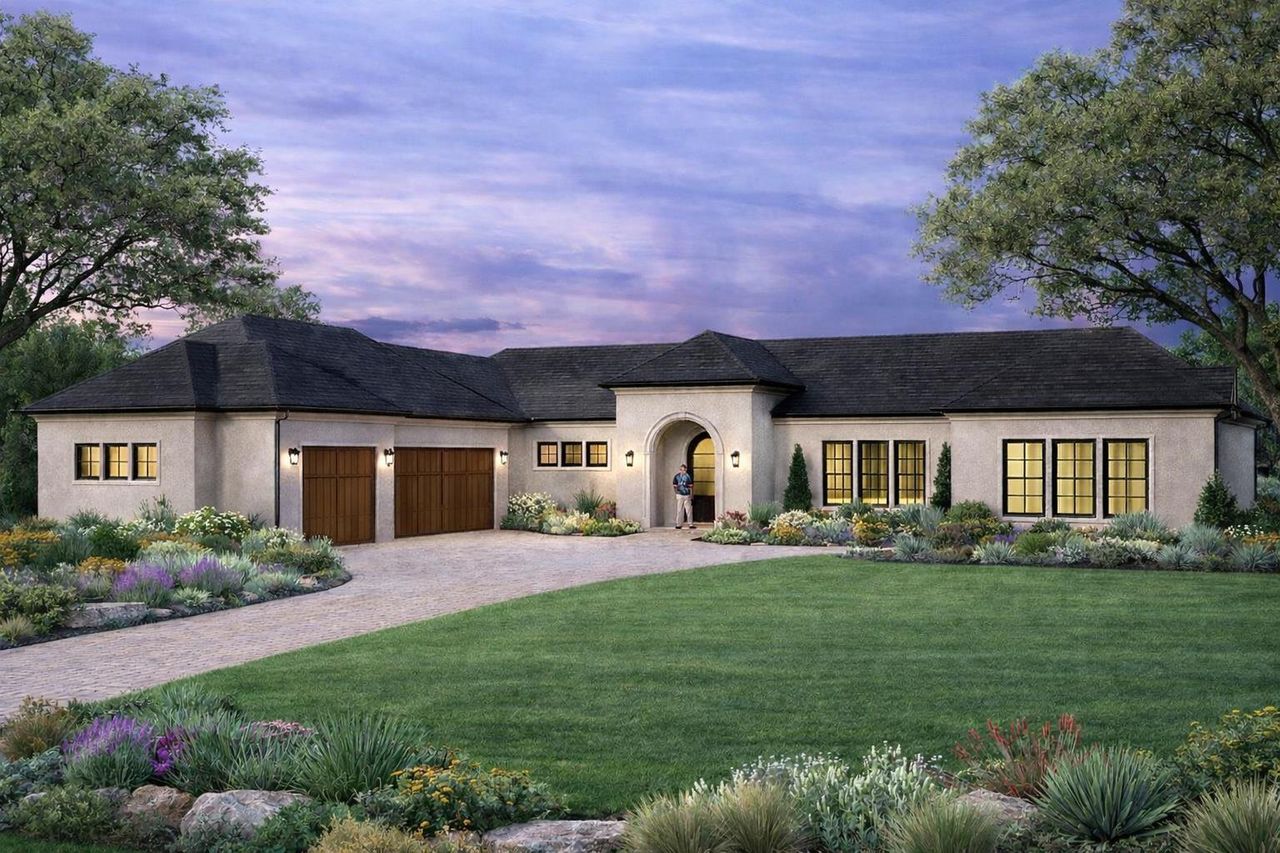 This property features a stucco exterior, a dark shingled roof, and a gravel driveway