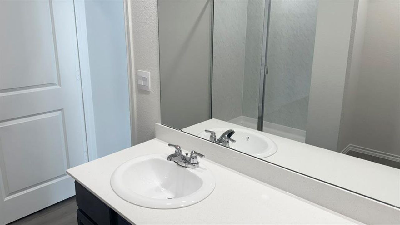 Bathroom featuring vanity and a textured wall Bathroom featuring vanity and a textured wall