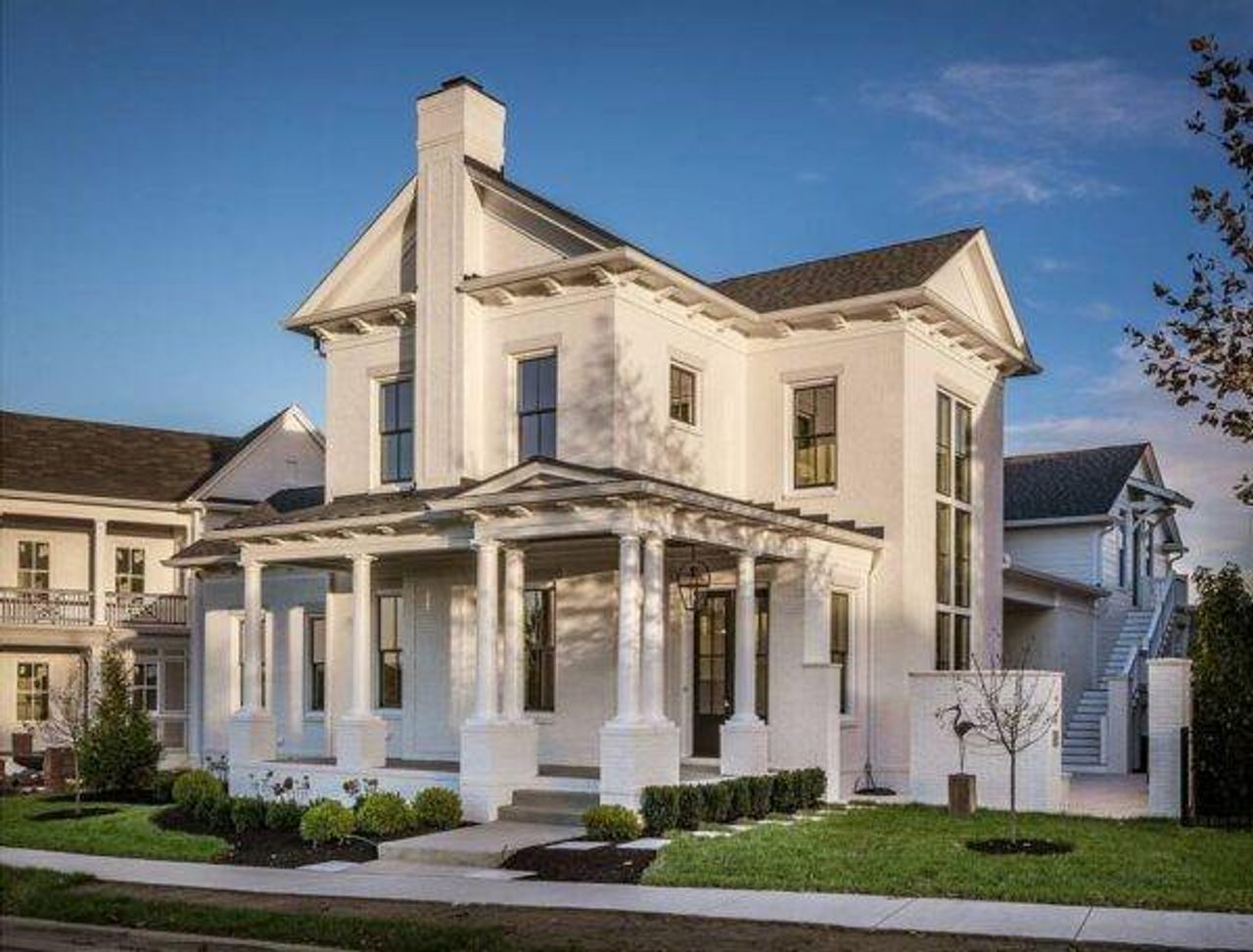 Front/Side view of house with a porch, a chimney, a yard, stairway, and stucco siding. Please note these are pictures of home to be built. Photos are copyrighted by C3Studios, LLC.
