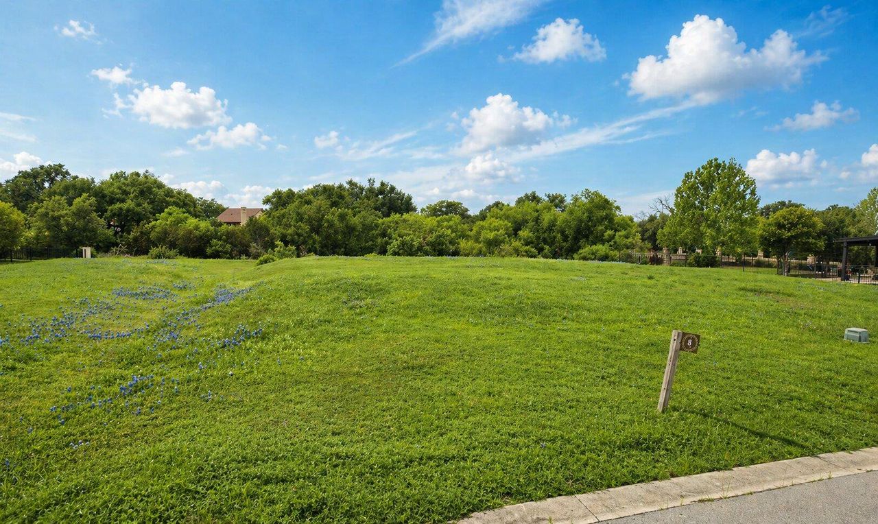 Expansive grassy lot featuring a gentle slope