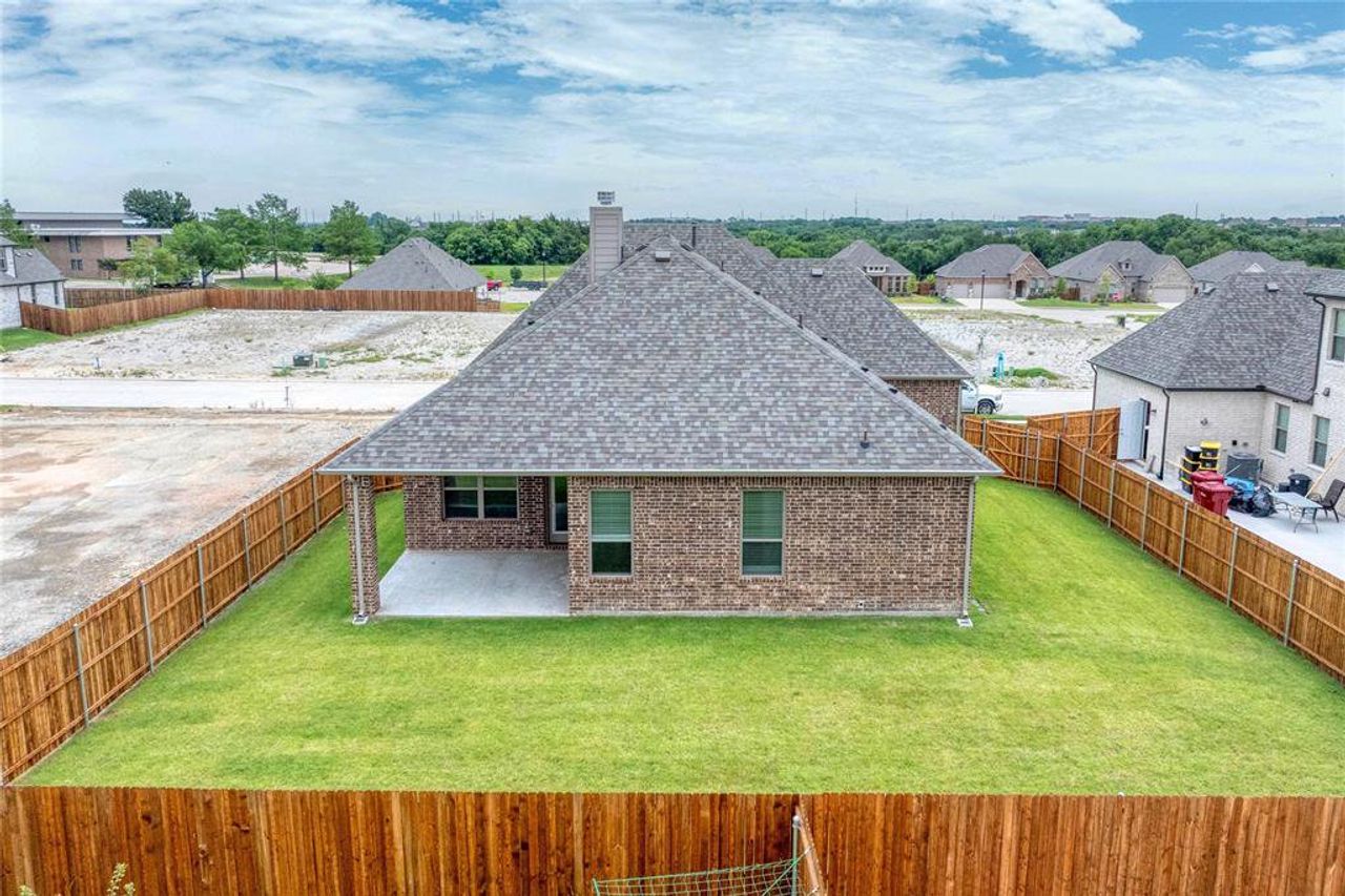 Back of property with roof with shingles, a fenced backyard, a patio area, and brick siding