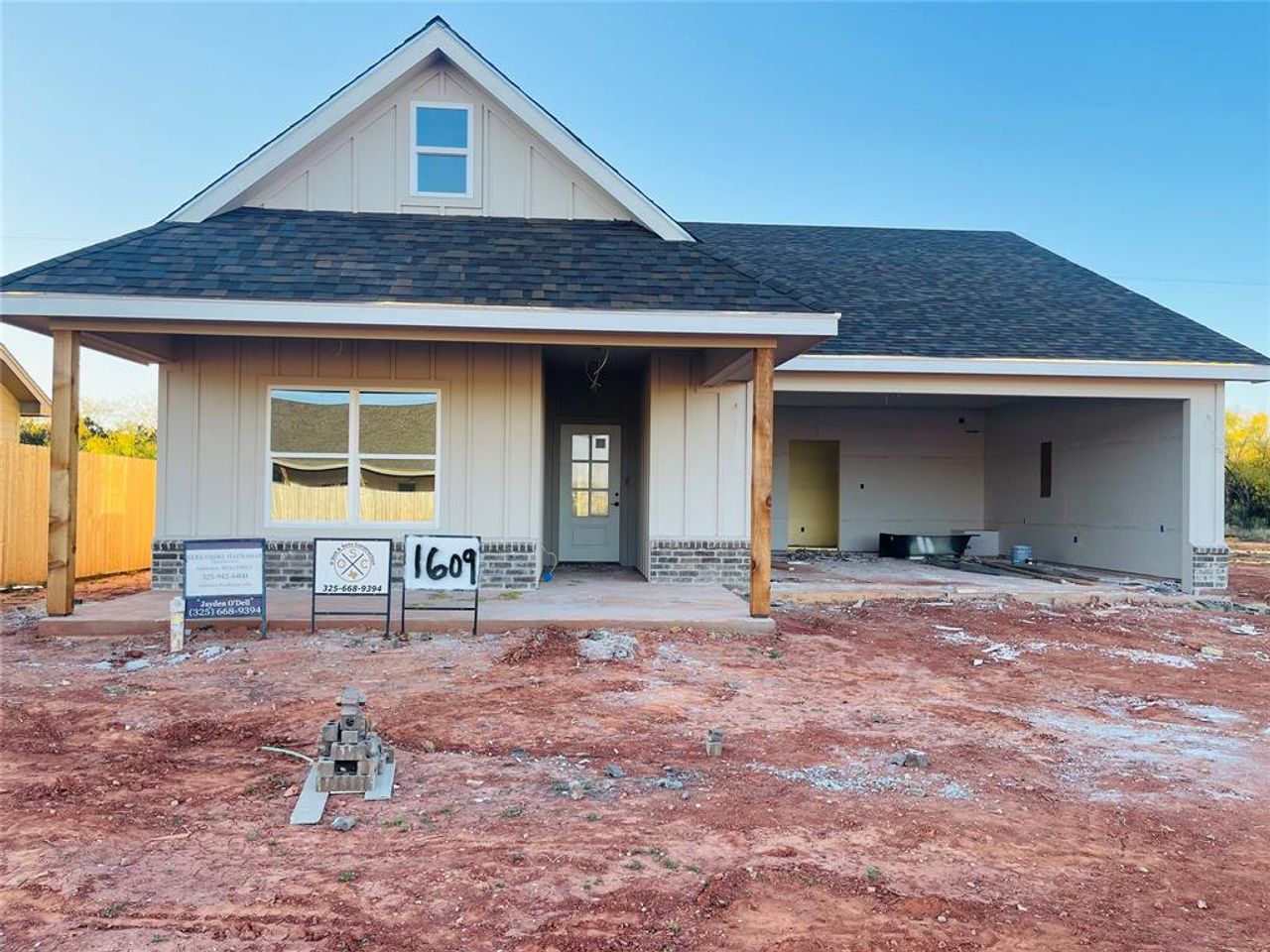 View of front facade featuring board and batten siding, a shingled roof, and covered porch