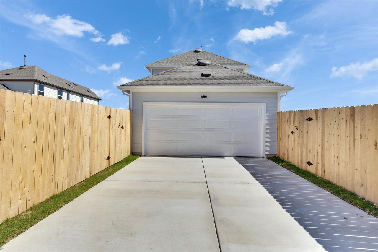 Garage featuring concrete driveway and fence Garage featuring concrete driveway and fence
