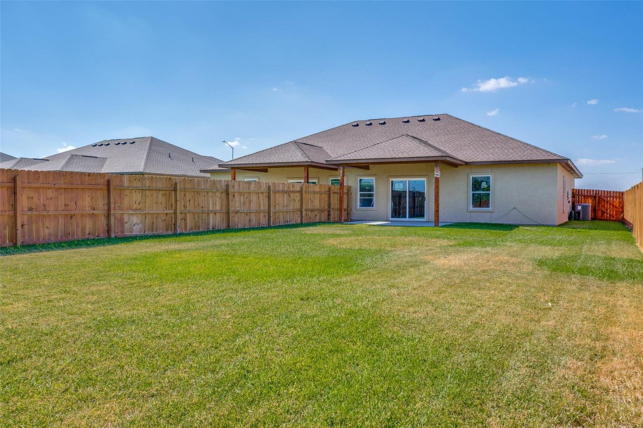 Rear view of property with a patio area, a fenced backyard, stucco siding, and a shingled roof