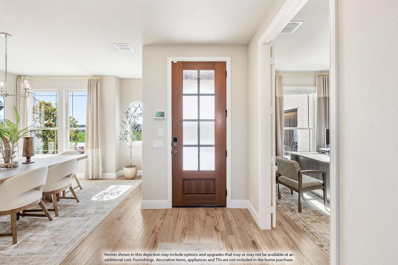 Entryway with wood front door featuring glass panels, hardwood floors, and view of dining room