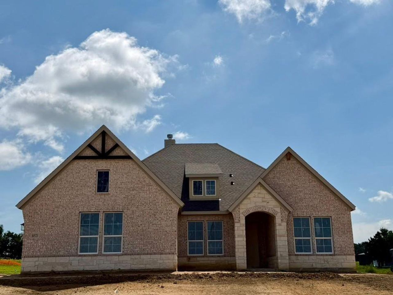 New construction residence featuring a brick and stone facade