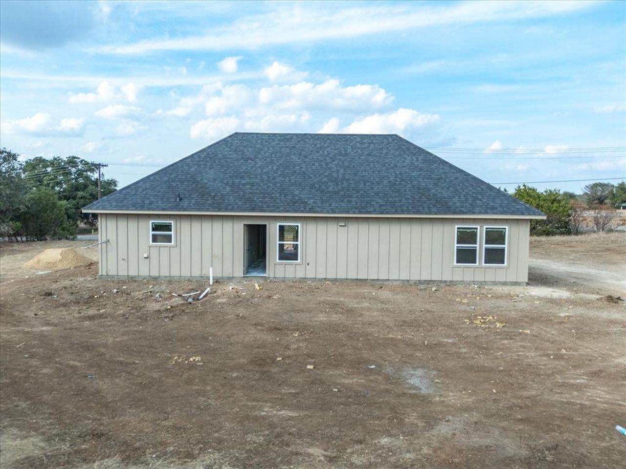 Rear view of house with roof with shingles and board and batten siding