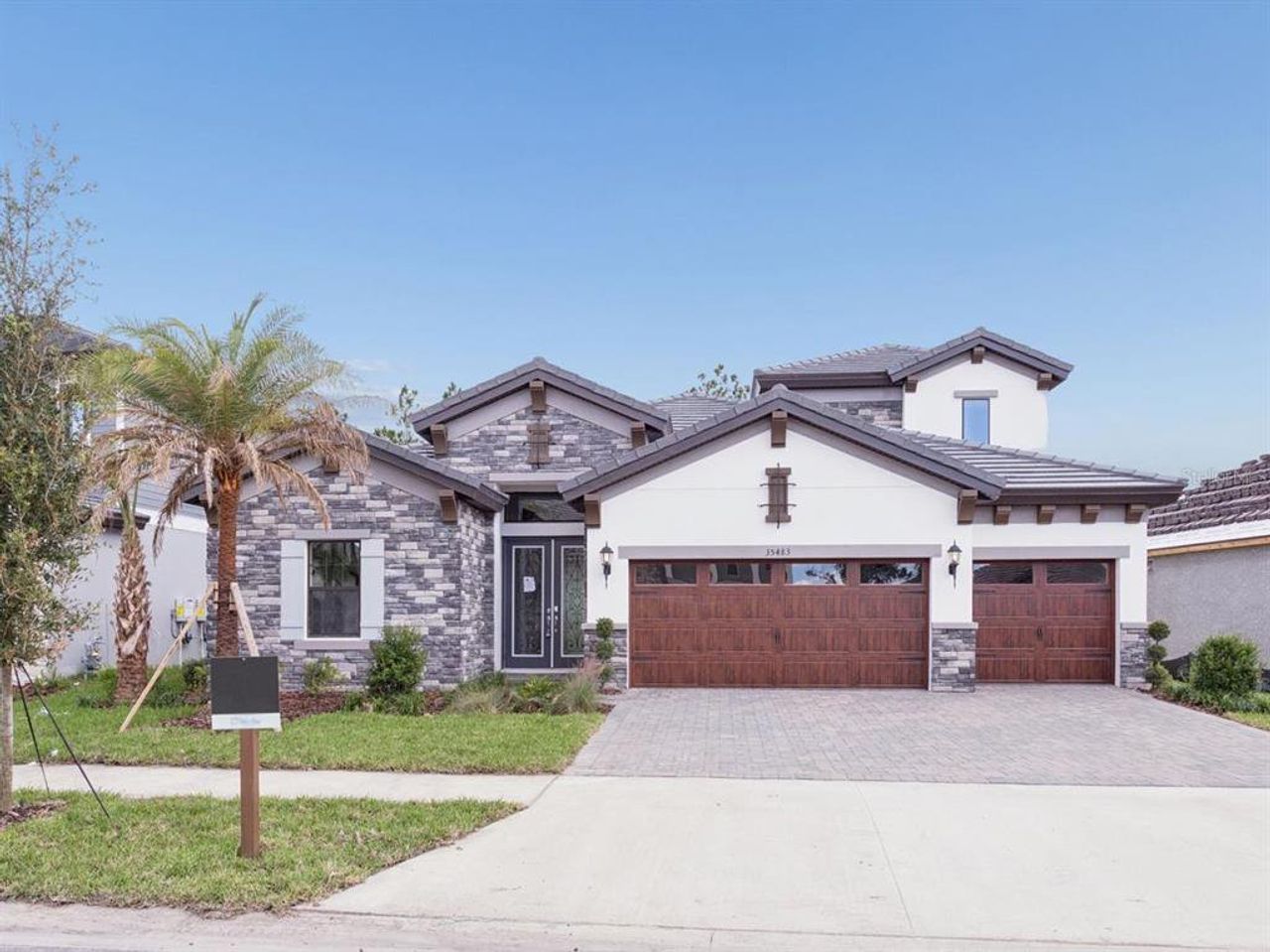 Front exterior of a new home in Two Rivers, Zephyrhills, FL, highlighting curb appeal (Image 2). Front exterior of a new home in Two Rivers, Zephyrhills, FL, highlighting curb appeal (Image 2).