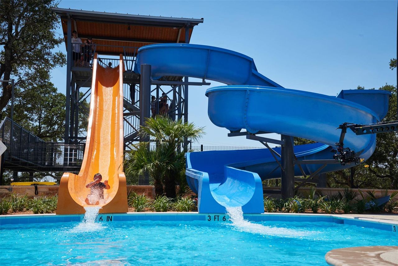 Waterpark-style slides featuring a multi-level tower structure and a clear blue pool